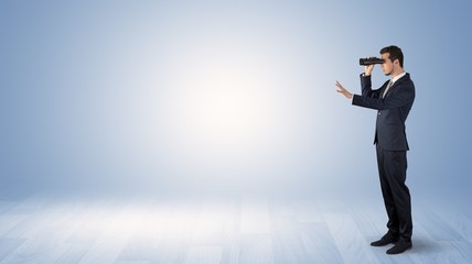 Wall Mural - businessman looking forward with binoculars in an empty space