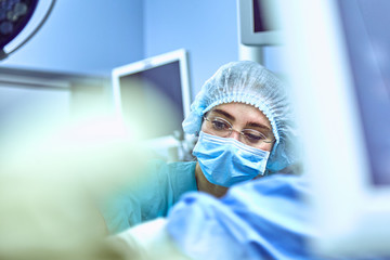 Wall Mural - Young Female Surgeon with Medical Team in Back on Surgery