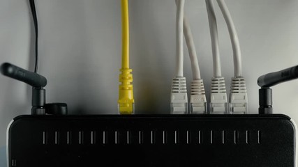 Wall Mural - A man disconnects the ethernet cable from the WAN and LAN ports of the WiFi router. Closeup