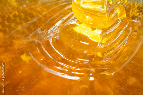Waves of fresh golden honey flowing through the filter sieve