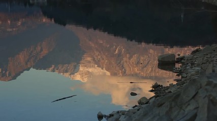 Wall Mural - Reflection of mountains and clouds on the lake at sunset