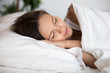 © fizkes - Young calm woman sleeping well alone on soft pillow comfortable mattress, millennial female with happy face rest asleep in cozy fresh bed having healthy peaceful sleep napping in the morning concept