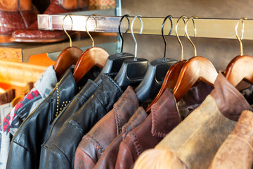 Leather jacket on hangers on a rack in retail store, aligned 