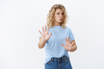 Wall Mural - Wow slow down. Intense and concerned woman breathing heavy raising hands in defense and no gesture folding lips alarmed step back as refusing and trying calm person acting crazy over white wall