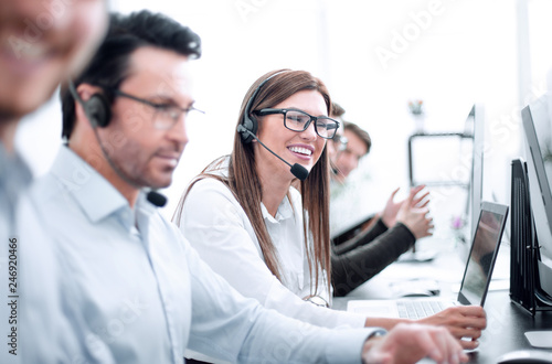 Fotomural woman call center operator and colleagues sitting at the Desk