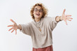 Girl wants hugs. Portrait of charming happy and enthusiastic attractive european female with short blond hair in glasses and sweater stretch hands to camera for cuddles and smiling friendly, welcoming
