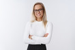 © Cookie Studio - Attractive female company hr smiling broadly standing in confident pose with crossed hands over body and friendly assured smile wearing elegant sweater and glasses, knowing how business works