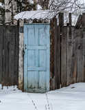 Fototapeta Na ścianę - Blue old door in a wooden fence
