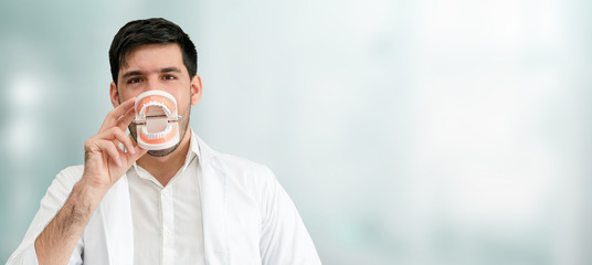 Young male dentist working in dental clinic. Dentistry care and medical service concept.