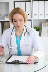 Wall Mural - Doctor woman at work. Physician filling up medical history records form at the desk. Medicine, healthcare  concept