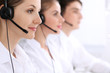 © rogerphoto - Call center operators. Focus at beautiful woman in headset