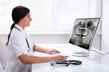 Dentist Looking At Teeth X-ray On Computer