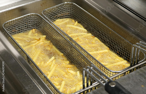 Cuadros en Lienzo potato chicps frying in a deep fryer