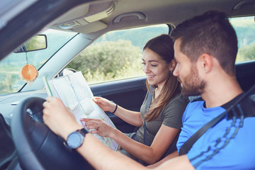 Happy couple traveling by car in the summer.