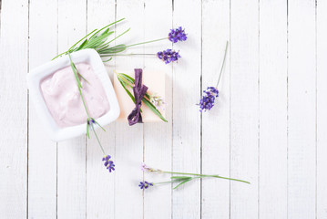 Wall Mural - pink moisturizer cream, soap bar and purple lavender flowers on white rusty wooden table background