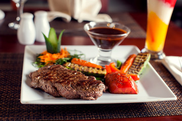 Wall Mural - Beef steak with grilled vegetables served on white plate. Food concept