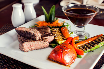 Wall Mural - Beef steak with grilled vegetables served on white plate. Food concept