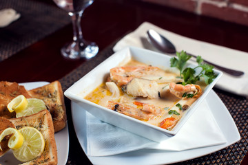 Wall Mural - Seafood cream soup with toasts in white plate on the table. Food and restaurant concept