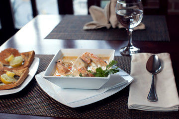 Wall Mural - Seafood cream soup with toasts in white plate on the table. Food and restaurant concept