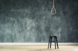 The old chair with the noose hanging at above with space of concrete wall at back, failure or commit suicide concept
