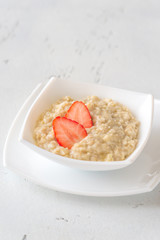 Canvas Print - Bowl of oats with fresh strawberries