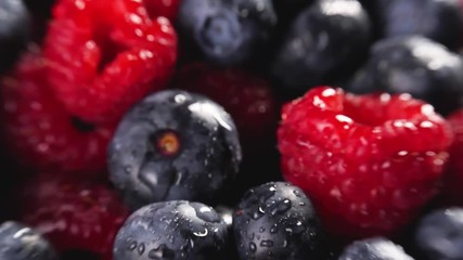 Wall Mural - Heap of fresh blueberries and raspberries rotating. Shallow depth of field. Follow focus. Closeup macro shot. Fresh berry series. 4k.