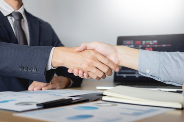 Wall Mural - shaking Hand between businessman of cooperation over Stock market chart, business trading concept