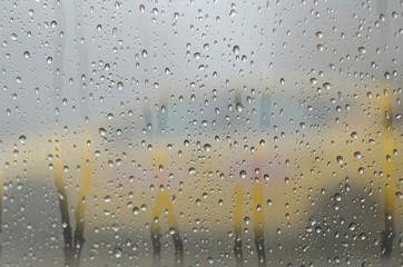 Raindrops on the window glass with outline of a taxi-cab