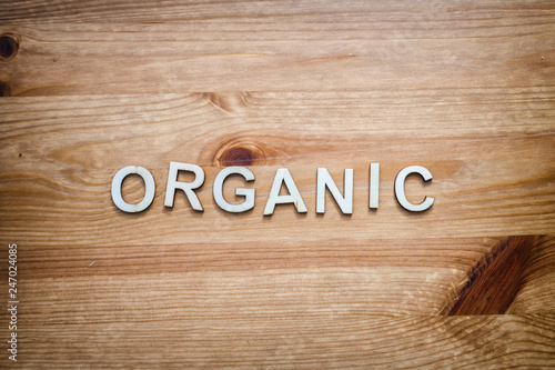 Fotomural The word organic being spelled by wood letters on a wood surface