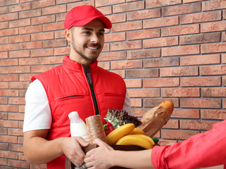 Canvas Print - Male courier delivering food to client indoors