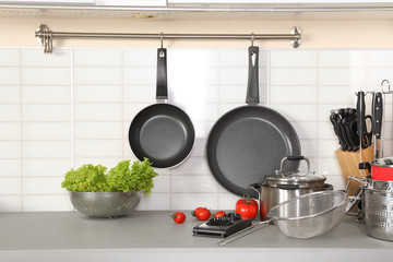 Poster - Set of clean cookware, utensils and products on table in modern kitchen