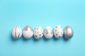 Painted Easter eggs on color background, top view