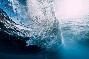 Wave underwater with air bubbles and sun light. Ocean in underwater