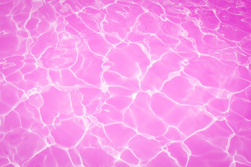 Wall Mural - Pink water surface with bright sun light reflections, water in swimming pool background