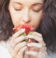 Wall Mural - young beautiful sensual woman with nice manicure holding the person red tropical flowers, natural be