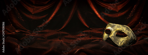 Fotografía Photo of elegant and delicate gold venetian mask over dark velvet and silk background
