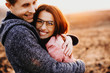 © Strelciuc - Lovely man hugging her woman laughing while traveling against sunset. Cute couple having fun together.