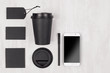Eco friendly coffee template for design, advertising and branding - black paper cup, blank screen phone, label, card, cap, sugar on white wood, copy space.