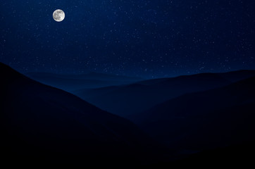 Wall Mural - mountain road through the forest on a full moon night. scenic night landscape of dark blue sky with 
