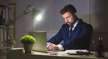 Businessman Working On Laptop In Dark Office