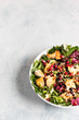 Salad mix with grilled turkey or chicken, seeds and citrus dressing on a white plate. Light concrete background. Healthy lunch or dinner. Copy space.