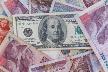 One hundred dollar bill on the egyptian pounds banknotes background