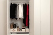 A well-organized closet. All things in their places, in boxes, on hangers, neatly stacked in piles. Capsule wardrobe. Storage system. Wardrobe order.