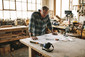 Senior carpenter studying drawing