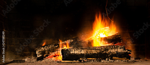 A glowing fire in the stone fireplace Poster Mural XXL