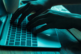 Fototapeta Boho - A computer programmer or hacker prints a code on a laptop keyboard to break into a secret organization system.