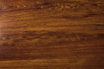 Polished wood texture. The background of polished wood texture with a dark amber color