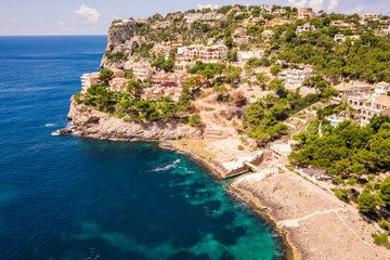 Wall Mural - Aerial view of villas residences on cliffs and clear blue green water bay Cala Marmassen Mallorca Spain