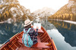 © EdNurg - Asian hipster Girl looking to the map inside wooden boat or canoe kayak tour at the background of the mountain lake in the Alps during fall season. Travel and vacation concept