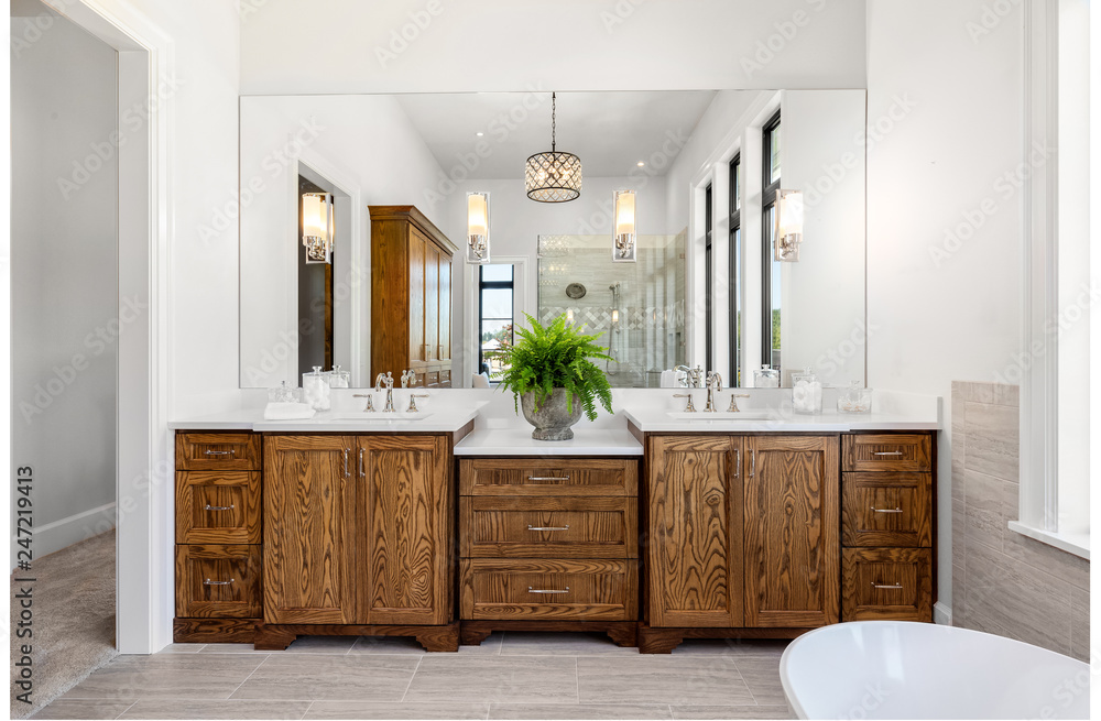 Beautiful bathroom in new luxury home, with double vanity, bathtub, and shower visible in mirror reflection. - obrazy, fototapety, plakaty 